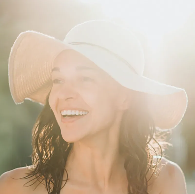 mujer con sombrero iluminada por el sol